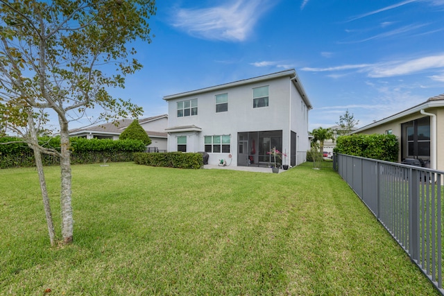 rear view of property featuring a sunroom and a yard