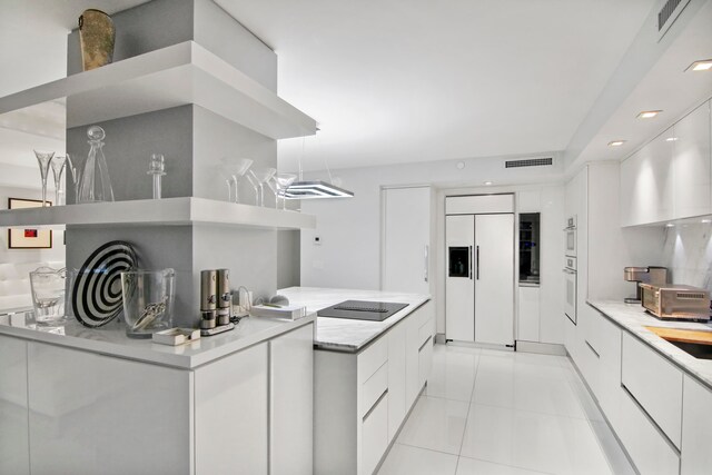 kitchen with black electric stovetop, white cabinetry, paneled built in refrigerator, and light tile patterned flooring