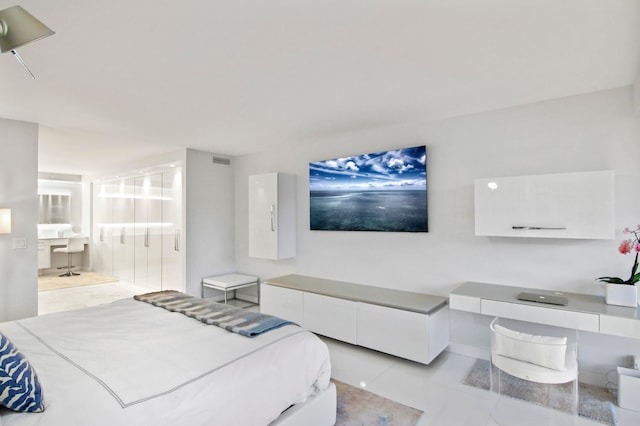 bedroom featuring ensuite bath and light tile patterned floors