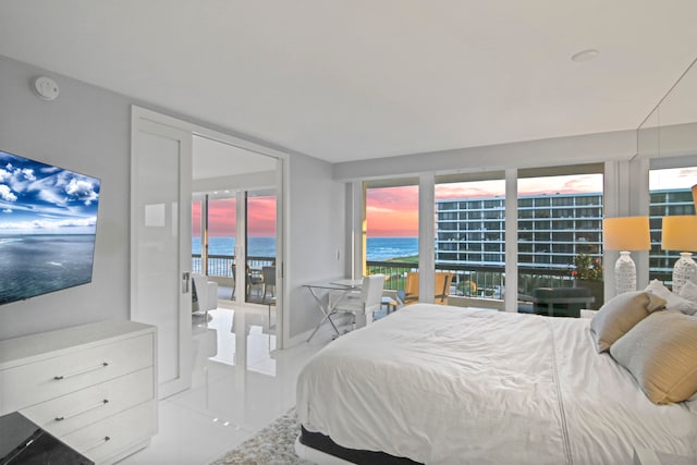 bedroom featuring multiple windows, a water view, and light tile patterned flooring