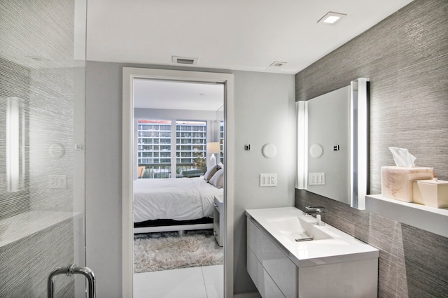 bathroom featuring tile walls, tile patterned flooring, and vanity