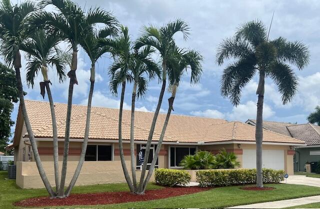 ranch-style home with a garage and a front lawn