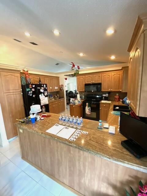 kitchen with kitchen peninsula, sink, light tile patterned flooring, and black appliances