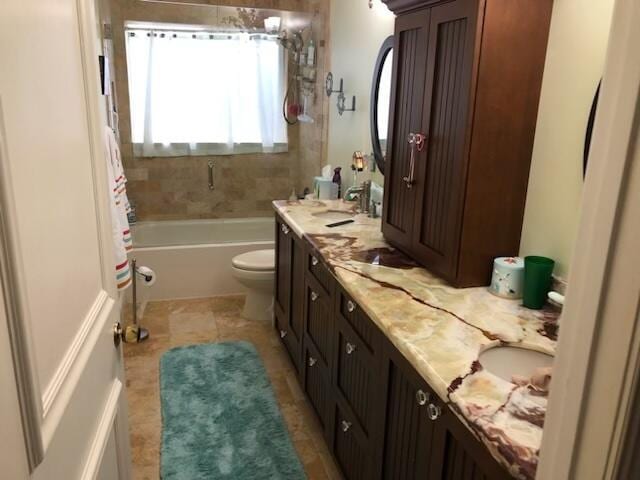 full bathroom with tiled shower / bath, tile patterned floors, vanity, and toilet