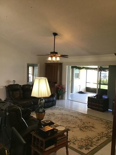 living room featuring ceiling fan and a healthy amount of sunlight