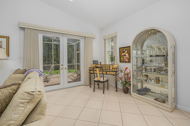 interior space with french doors, light tile patterned flooring, and vaulted ceiling