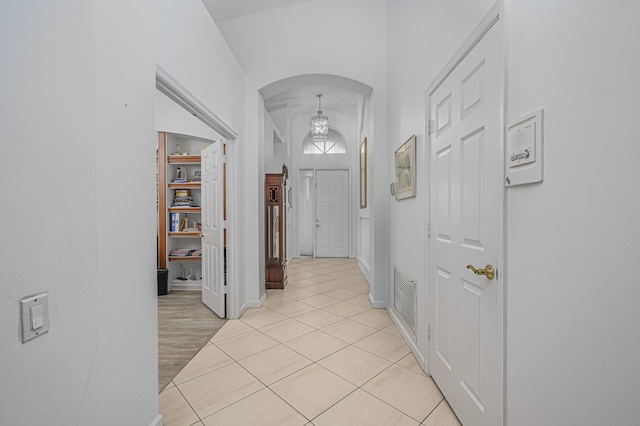 corridor with vaulted ceiling and light hardwood / wood-style flooring