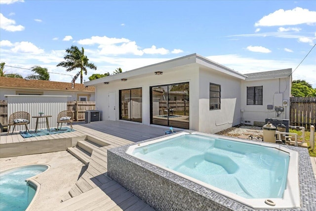 back of property featuring a pool with hot tub