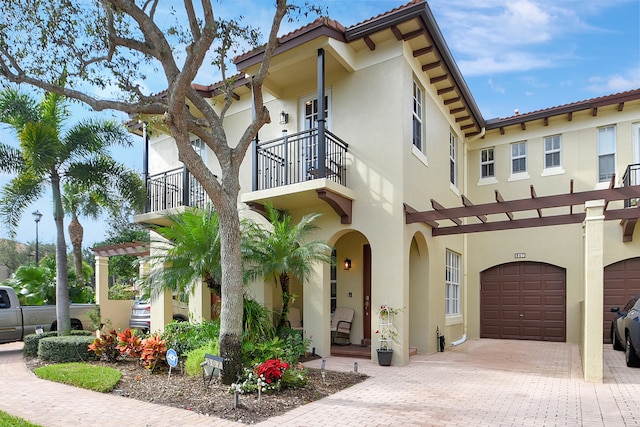 mediterranean / spanish-style house with a garage and a balcony