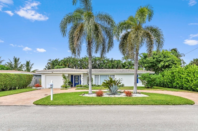 ranch-style house featuring a garage and a front yard