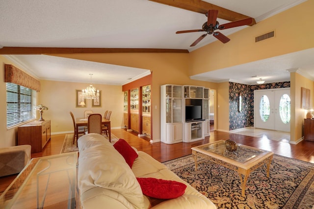 living room with ceiling fan with notable chandelier, hardwood / wood-style flooring, vaulted ceiling, and a wealth of natural light