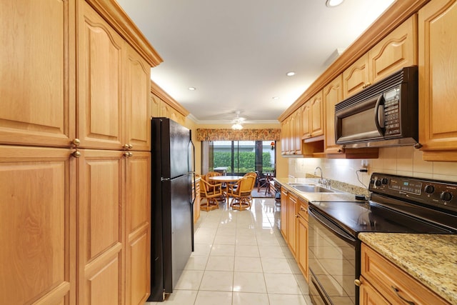 kitchen with light tile patterned floors, crown molding, light stone counters, black appliances, and ceiling fan