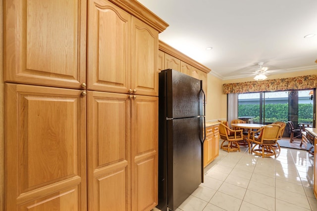 kitchen with ornamental molding, light brown cabinets, ceiling fan, black fridge, and light tile patterned flooring