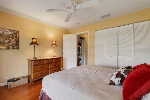 bedroom with hardwood / wood-style flooring, a closet, ceiling fan, ornamental molding, and a textured ceiling