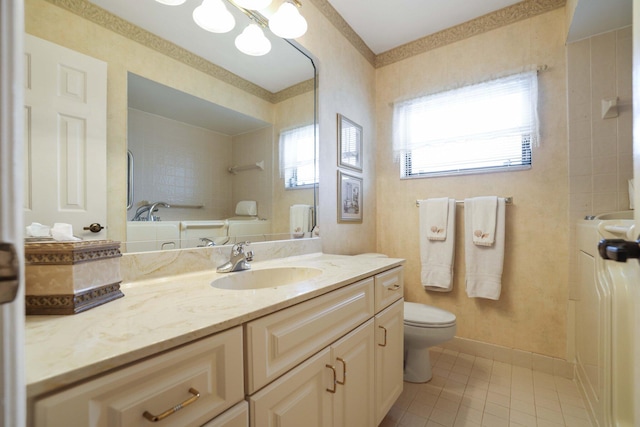 bathroom featuring a tub to relax in, vanity, toilet, and tile patterned floors