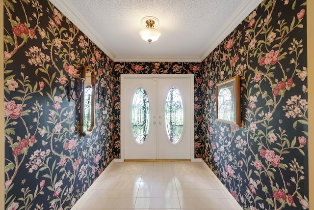 tiled entrance foyer with a textured ceiling, crown molding, and french doors