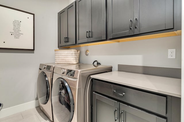 laundry room with cabinets, washing machine and clothes dryer, and light tile patterned flooring