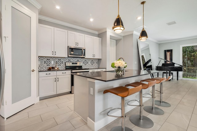 kitchen featuring pendant lighting, white cabinetry, a breakfast bar area, and stainless steel appliances