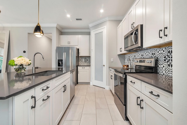 kitchen featuring decorative light fixtures, appliances with stainless steel finishes, crown molding, sink, and white cabinetry