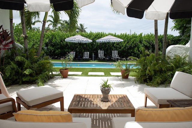 pool with outdoor lounge area and a patio