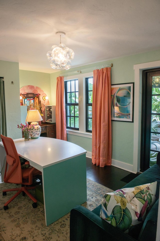 office featuring an inviting chandelier, baseboards, and wood finished floors