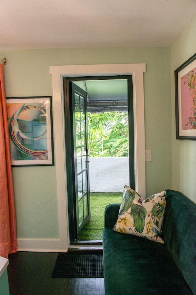 doorway to outside with baseboards and wood finished floors