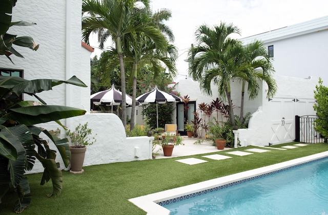 view of swimming pool with a patio, fence, a fenced in pool, and a yard