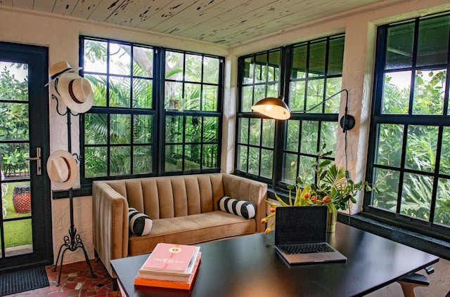 sunroom featuring wood ceiling and a healthy amount of sunlight