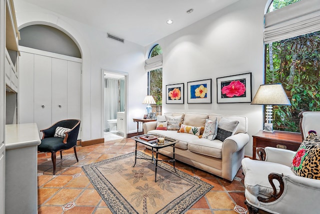 living room featuring a towering ceiling and a wealth of natural light