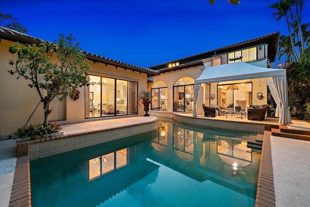 pool at twilight featuring a patio