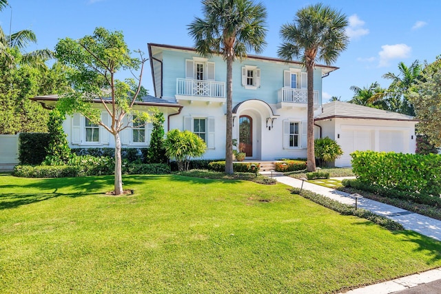 mediterranean / spanish home with a balcony, a garage, and a front yard