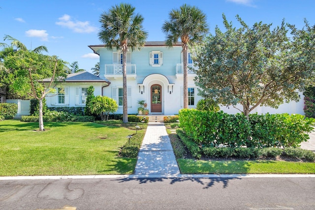 view of front of property with a balcony and a front yard