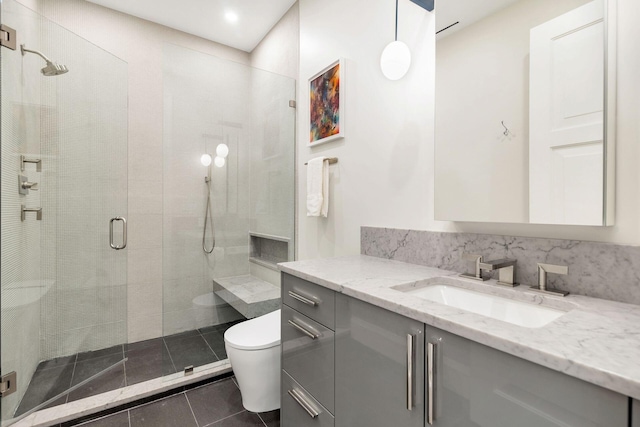 bathroom featuring tile patterned floors, a shower with shower door, vanity, and toilet