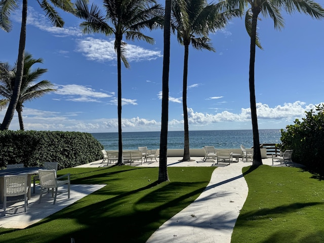 view of community with a patio, a water view, and a yard