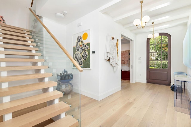 entrance foyer with beamed ceiling, a notable chandelier, and light hardwood / wood-style floors