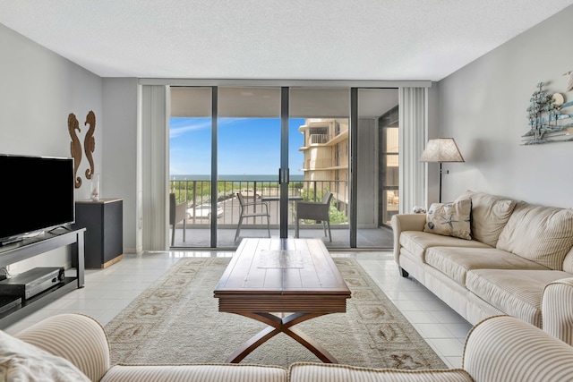 living room with a textured ceiling, light tile patterned floors, and floor to ceiling windows