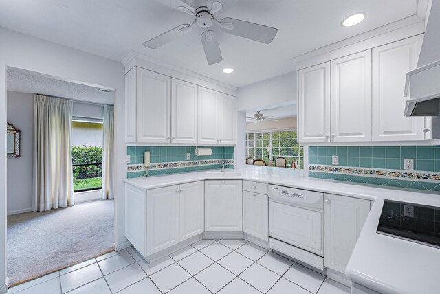 kitchen with a healthy amount of sunlight, white dishwasher, ceiling fan, and decorative backsplash