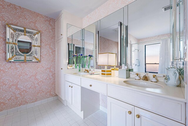 bathroom with tile patterned flooring, vanity, and a shower