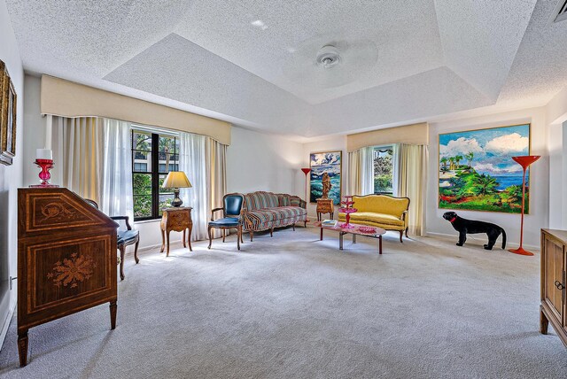 living area featuring a wealth of natural light, carpet floors, and a textured ceiling