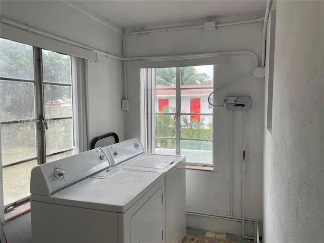 laundry area featuring laundry area, washing machine and clothes dryer, and a wealth of natural light