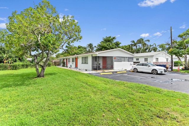 ranch-style house with uncovered parking and a front yard