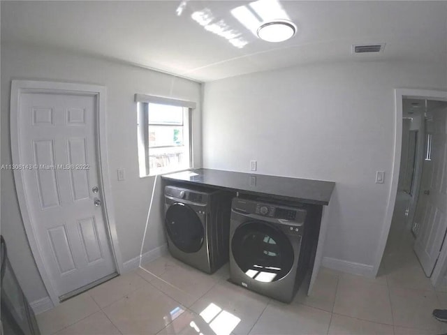 laundry area featuring laundry area, light tile patterned floors, baseboards, visible vents, and independent washer and dryer