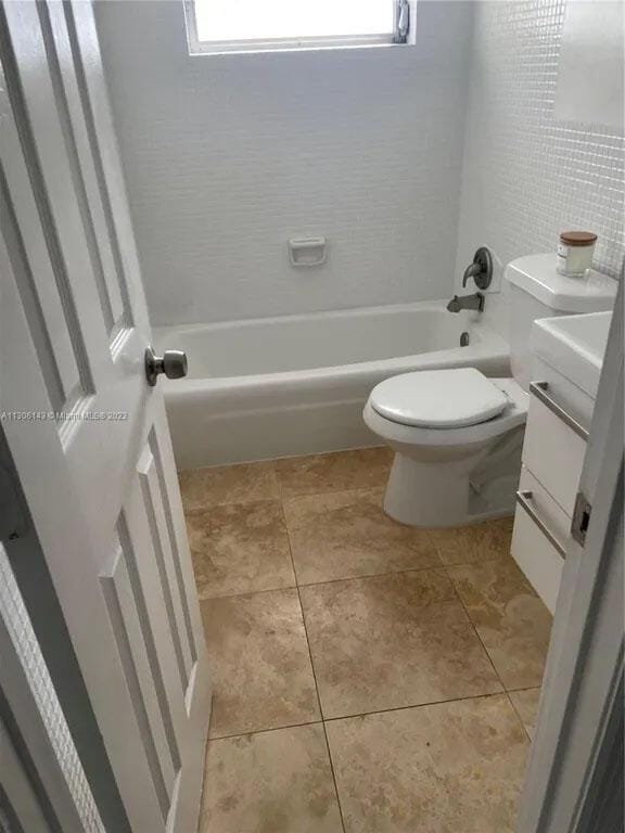 full bathroom with  shower combination, tile patterned flooring, vanity, and toilet