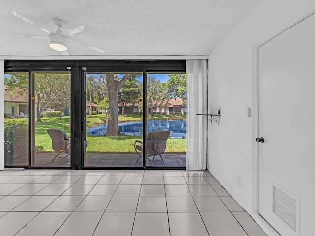 entryway with a textured ceiling, ceiling fan, and plenty of natural light