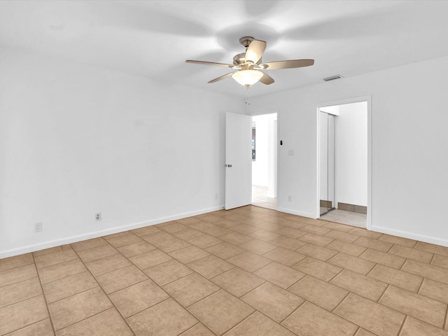 tiled empty room featuring ceiling fan