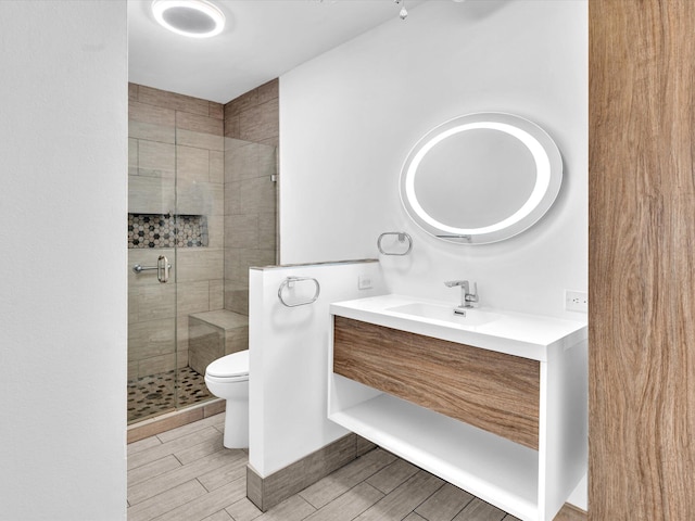 bathroom with walk in shower, vanity, and toilet