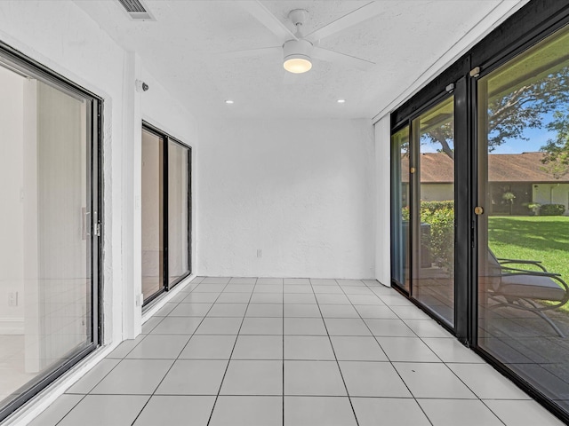 unfurnished sunroom featuring ceiling fan