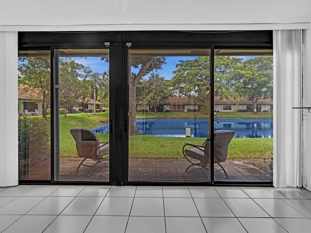 doorway featuring a water view and light tile patterned floors