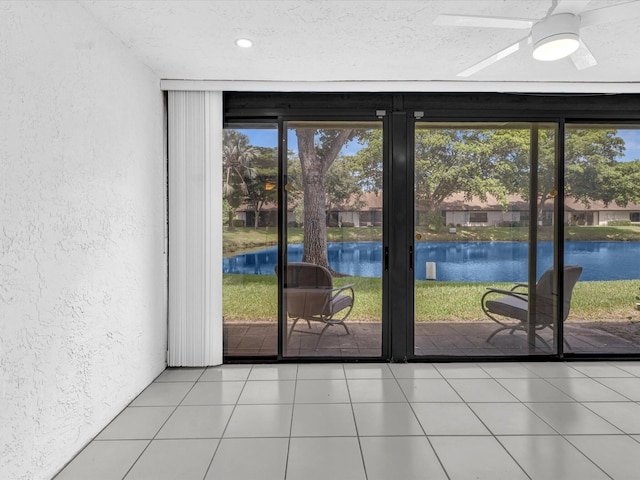 interior space with a water view, ceiling fan, and plenty of natural light