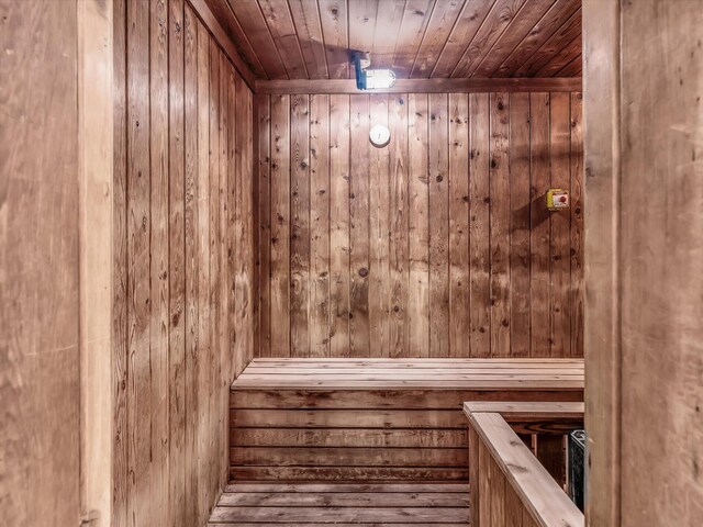 view of sauna / steam room with wooden ceiling and wooden walls